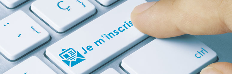 un doigt appui sur le bouton Je m'inscris d'un clavier d'ordinateur