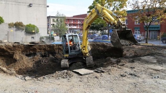 une mini-excavatrice retire le sol contaminé d'un site