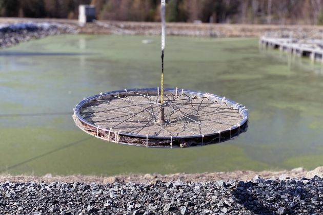 Roue de bicyclette équipé d'un fin treillis métallique d'un côté et attaché à une corde graduée de l'autre.