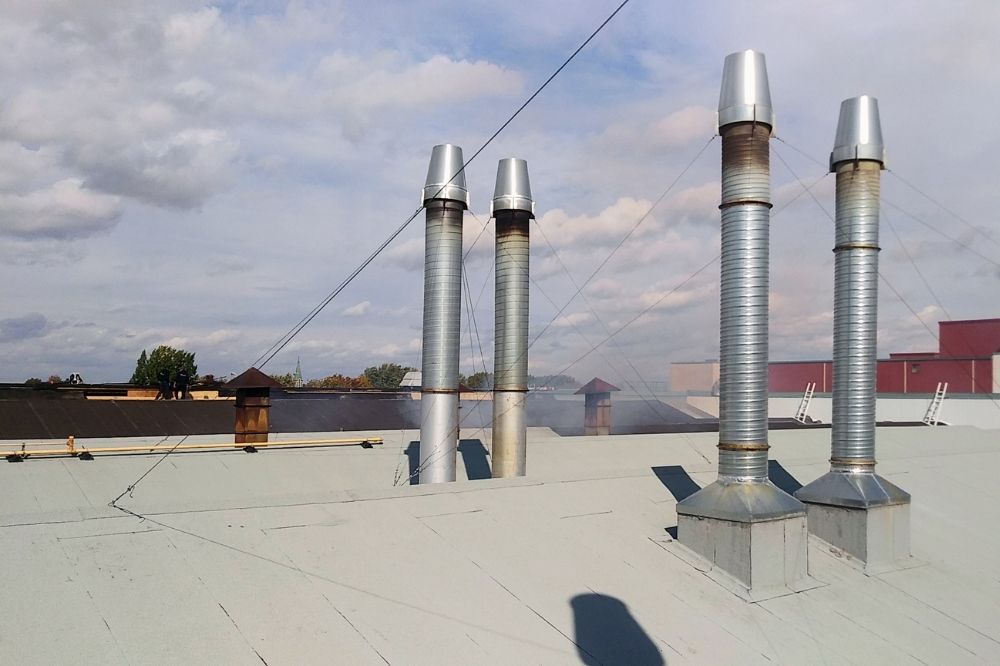 Quatre cheminées en galvanisé sur le toit d'une usine