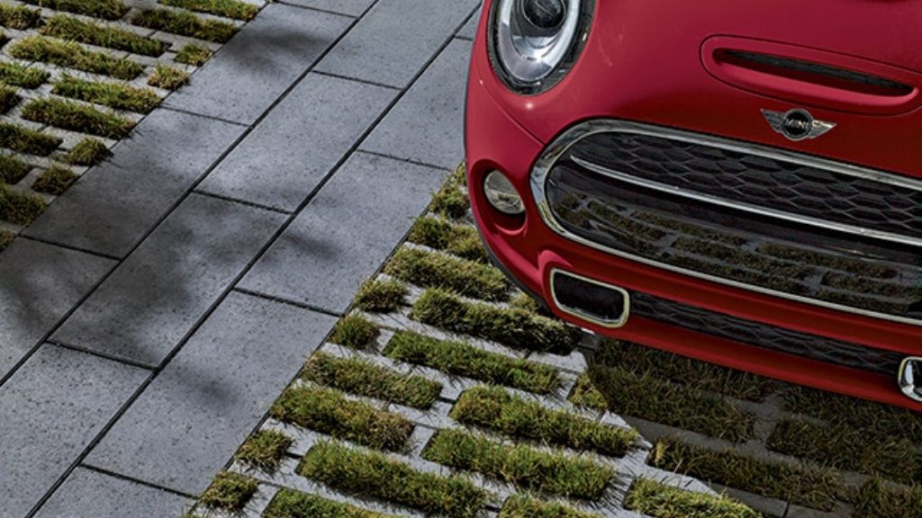 un pavé de béton alvéolé supporte une voiture qui y est stationnée