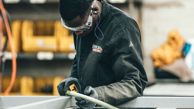 Un employé mesure un cadre formé d'extrusion d'aluminium