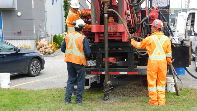 Trois personnes sont occupés au forage d'un puits d'exploration