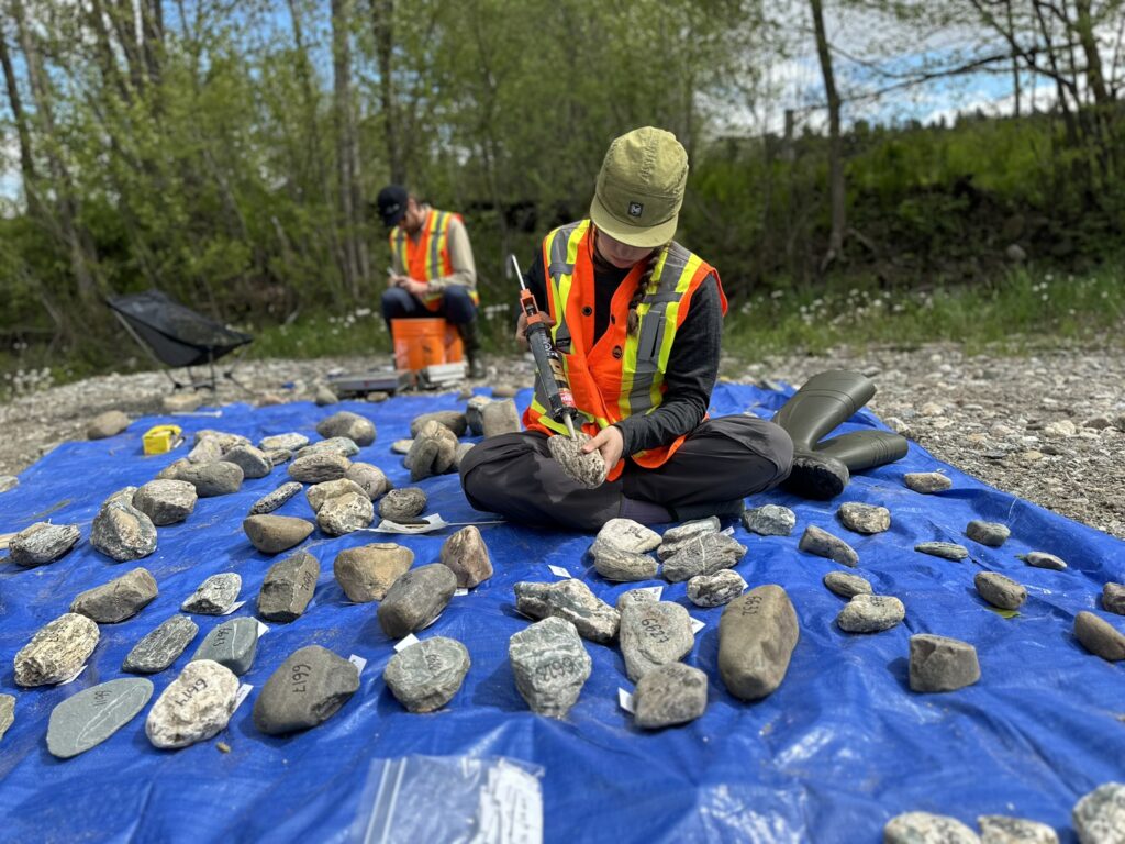 Professionnel d'Avizo analysant des échantillons sédimentaires sur le terrain lors d'une étude hydrogéomorphologique.