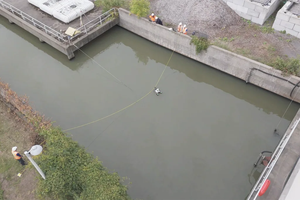 Équipe MSQE d'Avizo guidant un ADCP flottant sur un câble tendu en travers du canal d'effluent